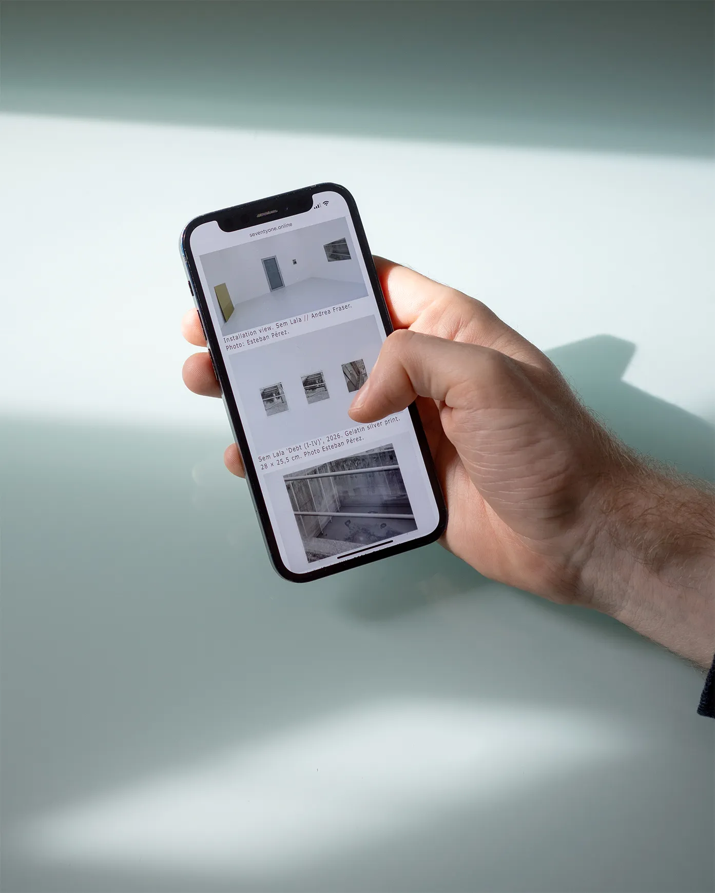 An iPhone displaying the mobile view of the exhibition details page.