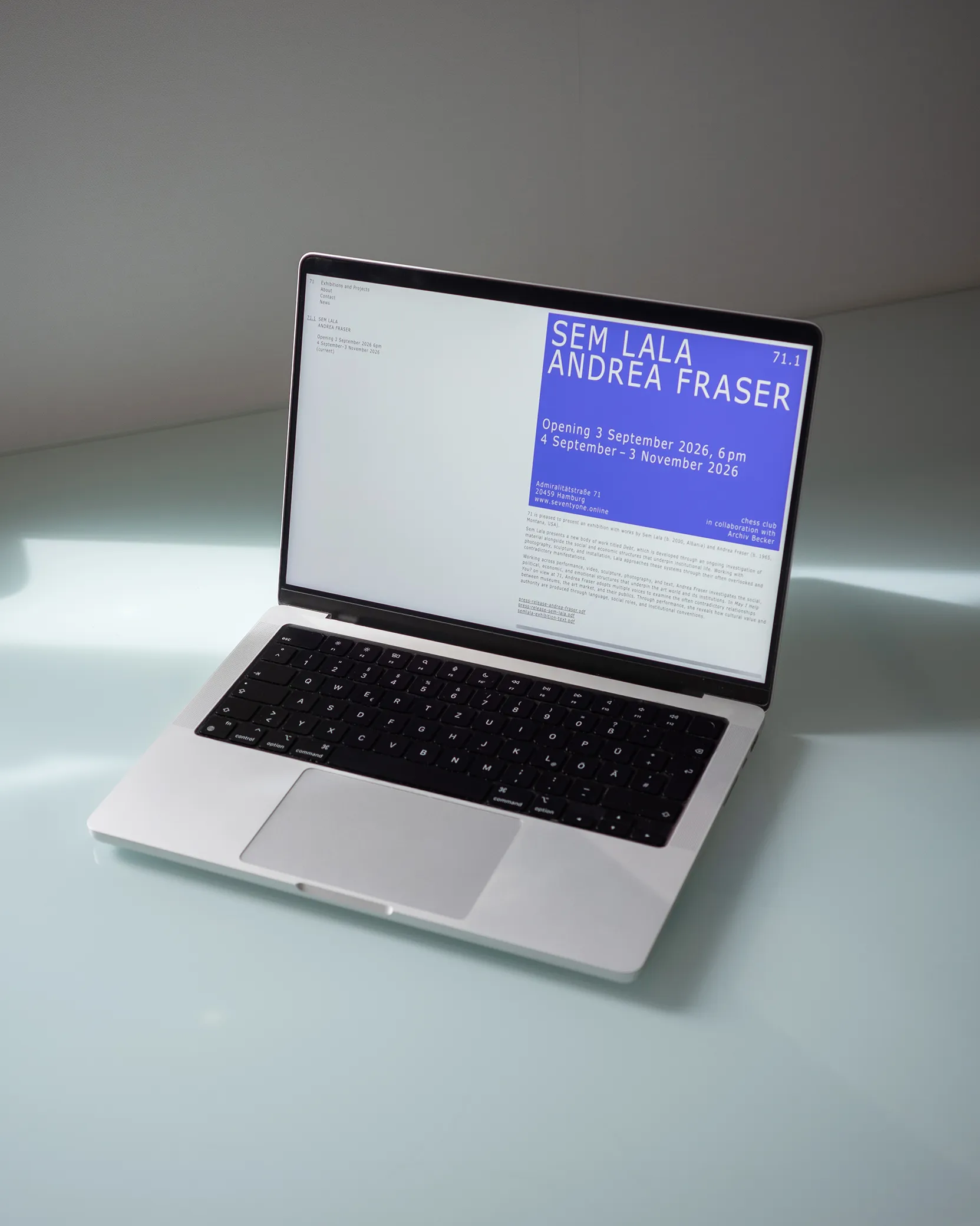 A MacBook displaying the gallery website homepage.
