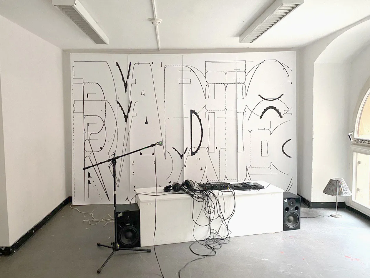 Broadcasting booth with DJ equipment set against a large multi-panel pen-plotted backdrop featuring abstracted 'RADIO' line typography.