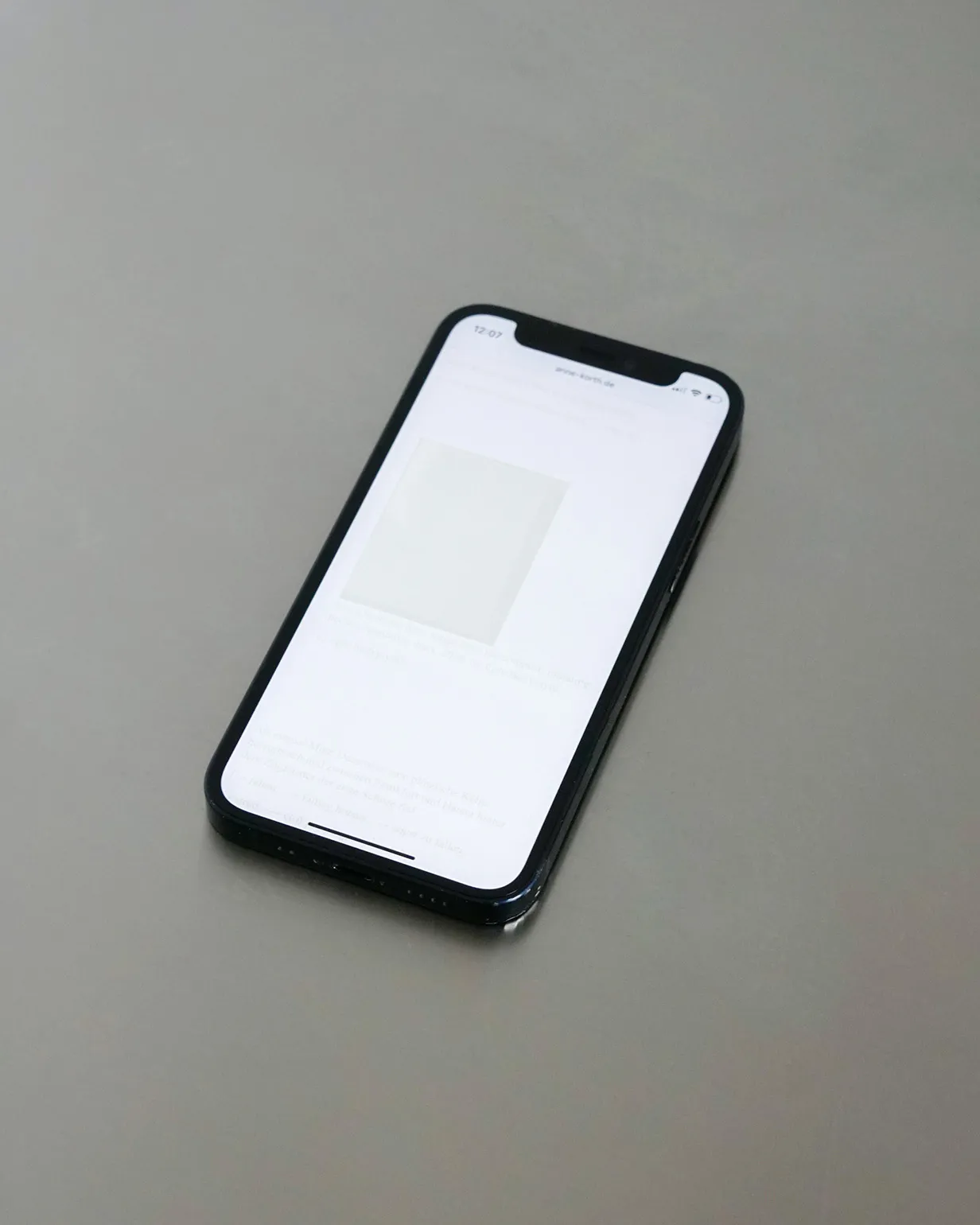 iPhone displaying the mobile layout of the website with a softly faded overlay.