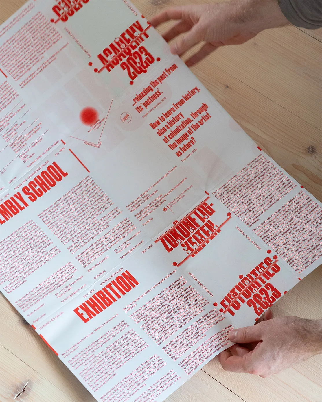 Person holding the unfolded flyer in their hands